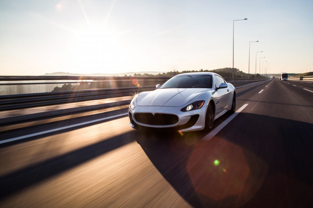front view of high speed silver sport car in highway
