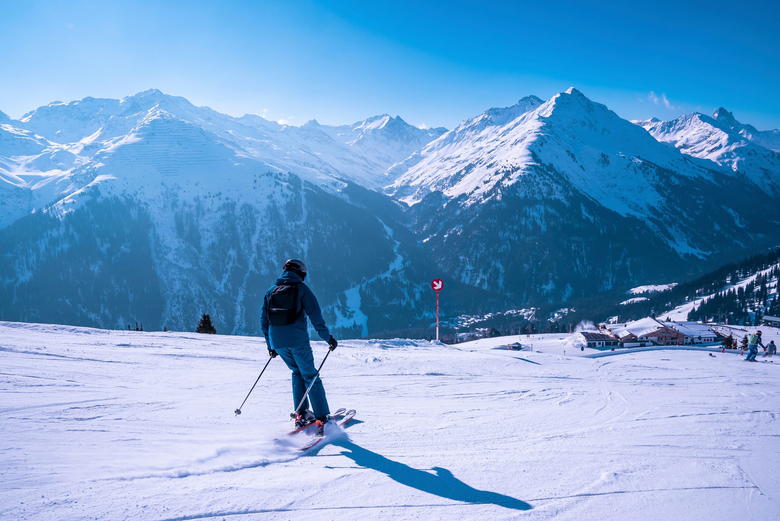 Male skier skiing on snowy landscape against mountain range