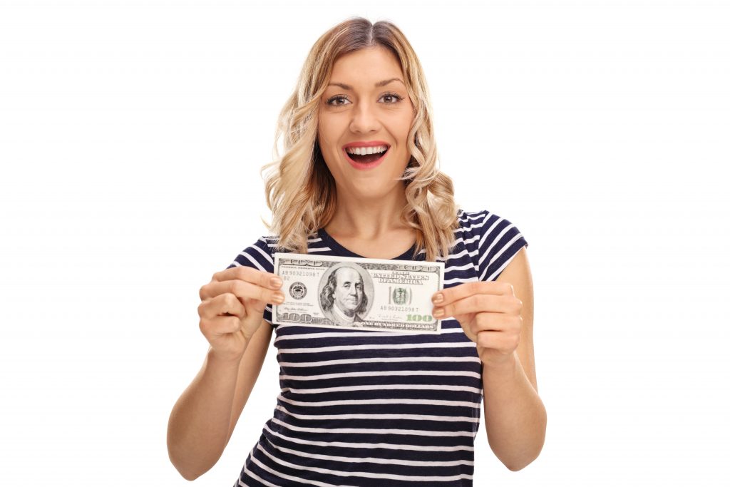 Woman holding a hundred dollar bill to buy cheapest thing