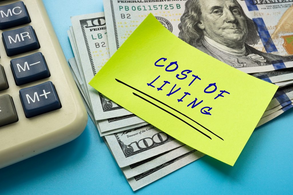 Business concept about COST OF LIVING with phrase on the piece of paper.