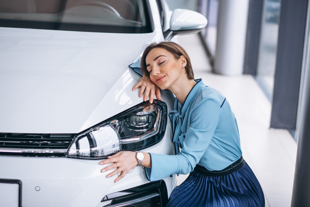 woman hugging white car