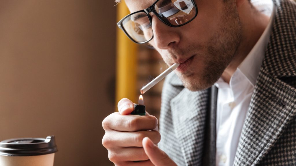 close up image businessman with eyeglasses sitting by table smoking tobacco drinking coffee impact finances