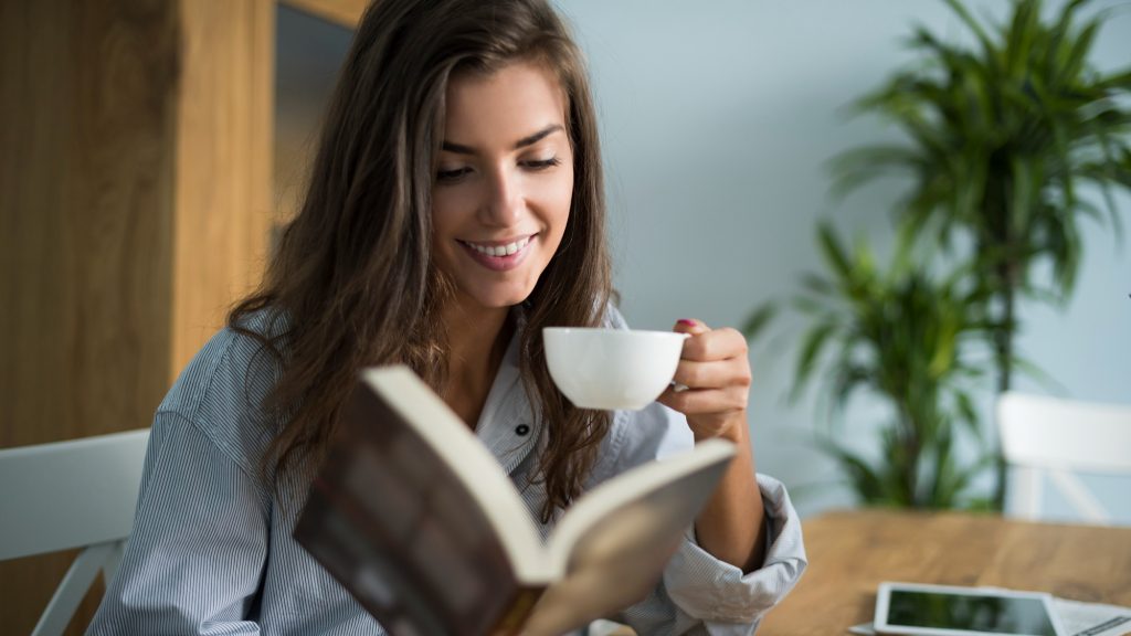 woman read book with cup of coffee