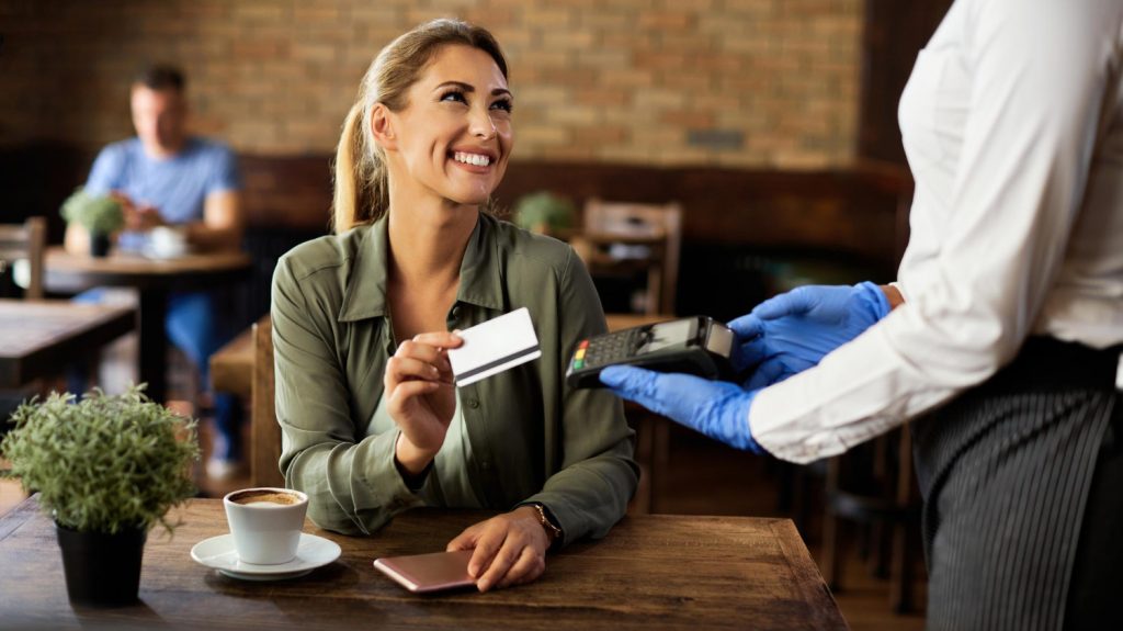 happy woman paying with credit card cafeteria 