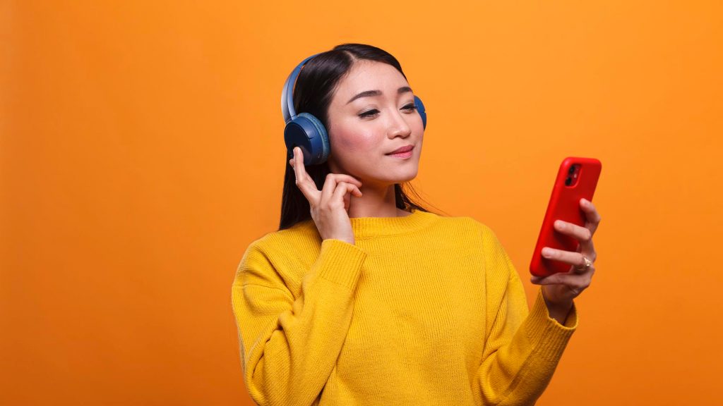 relaxed asian woman loistening music on streaming platform