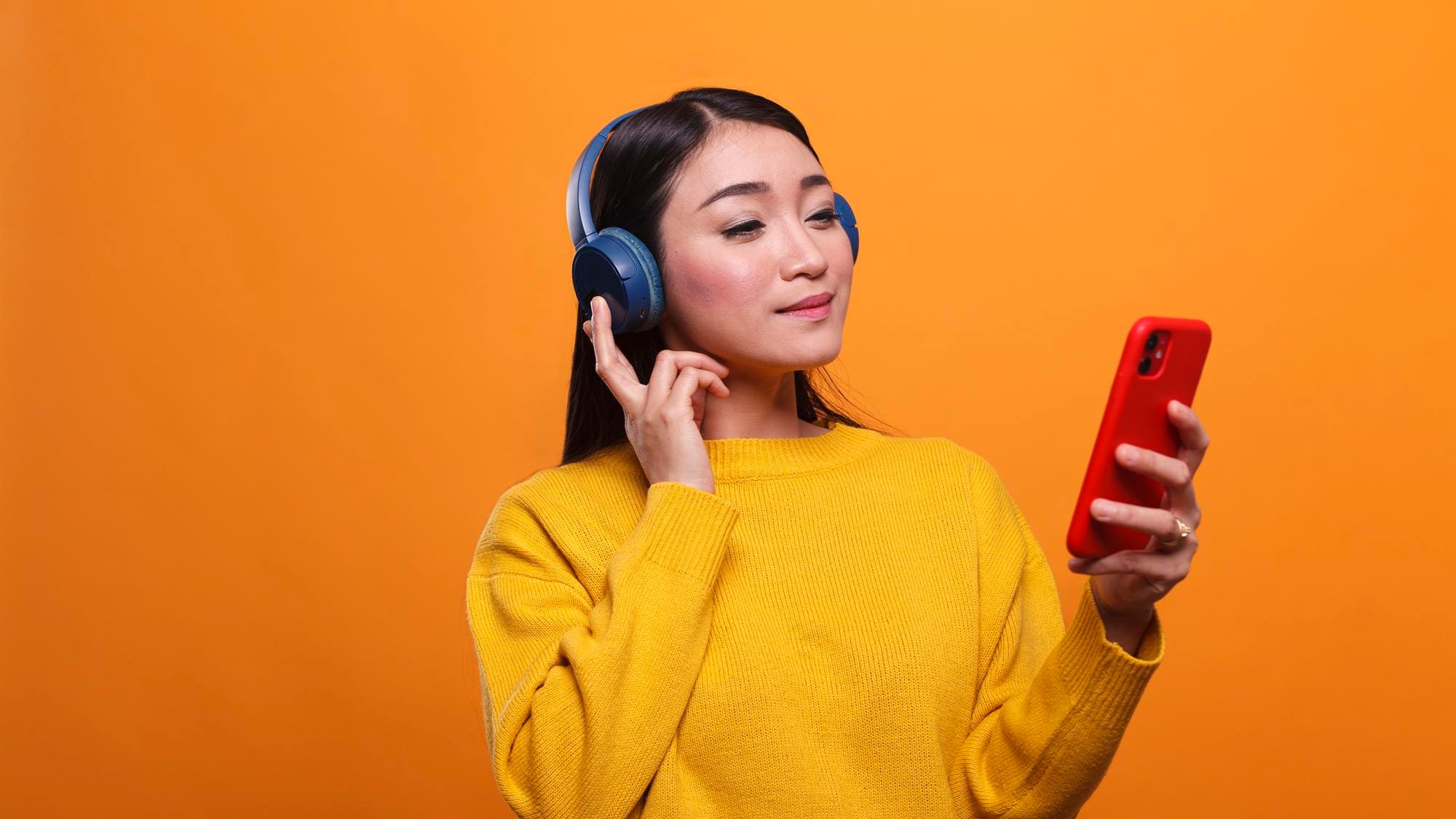 relaxed asian woman loistening music on streaming platform