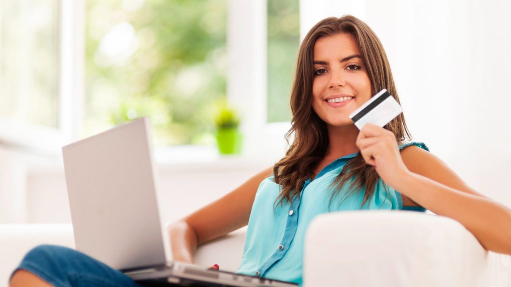 smilling woman using secured credit card to improve credit score