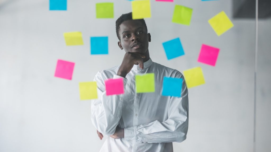 young business man looking at post-it plans goals