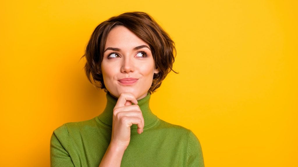 Closeup photo of amazing short hairdo lady looking up empty space, deep thinking creative person arm on chin wear casual green turtleneck isolated yellow color background