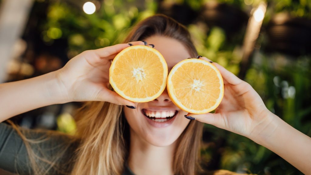happy woman holding orange slices