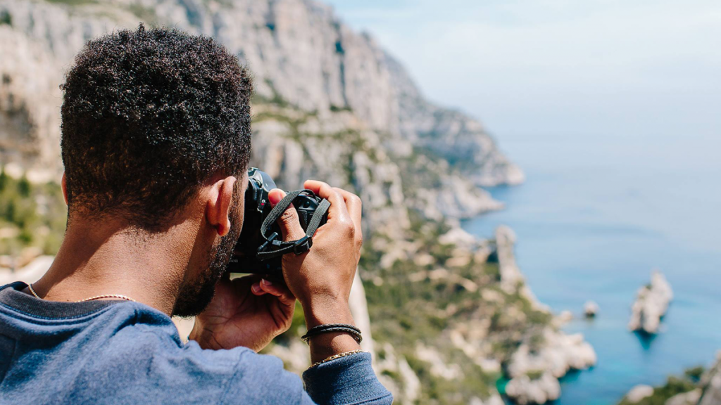 black man taking a photograph of a beautiful view