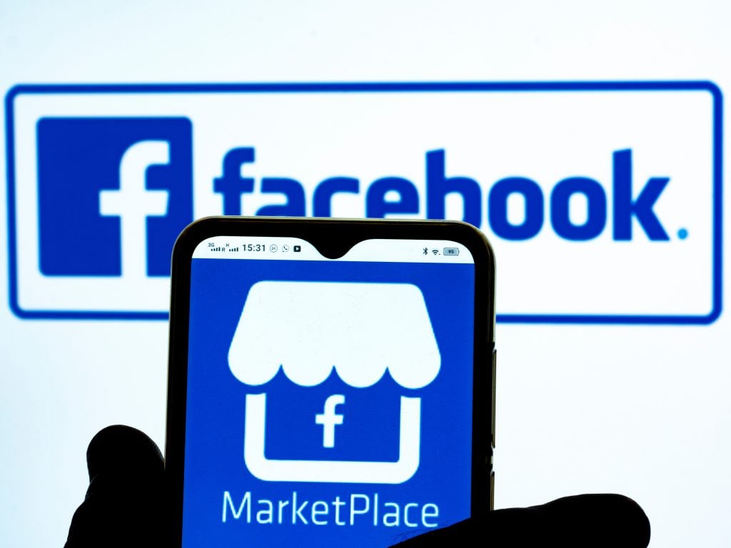 In this photo illustration, the Marketplace by Facebook icon is seen displayed on a smartphone screen with the Facebook logo in the background.